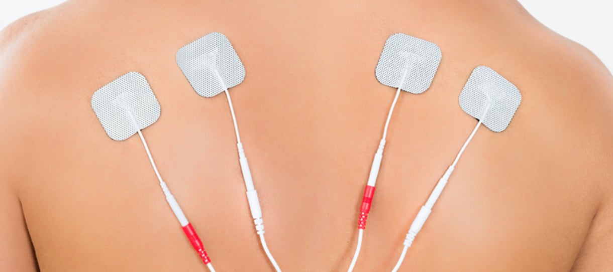 Aufgeklebte Pads im Schulterbereich zur Elektrotherapie